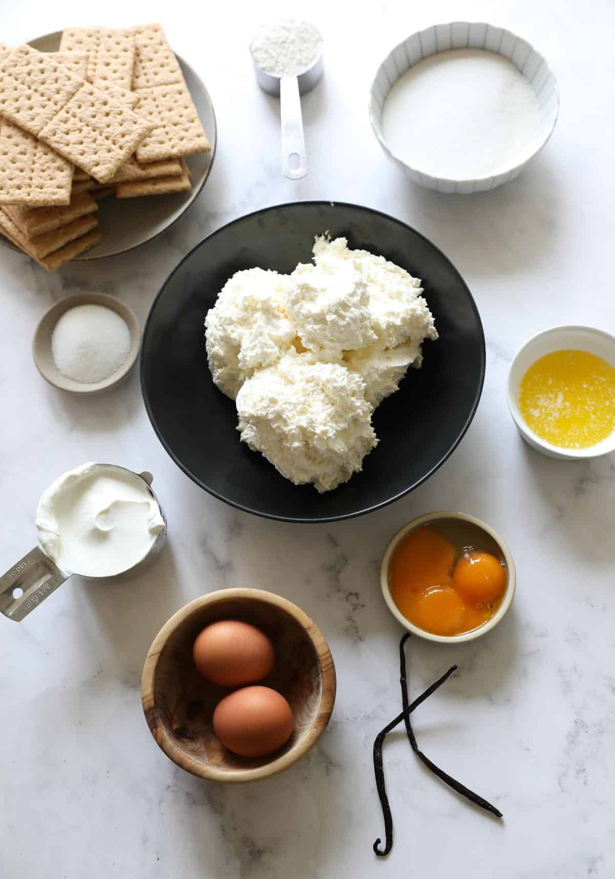 Ingredients for a cheesecake recipe laid out on a counter