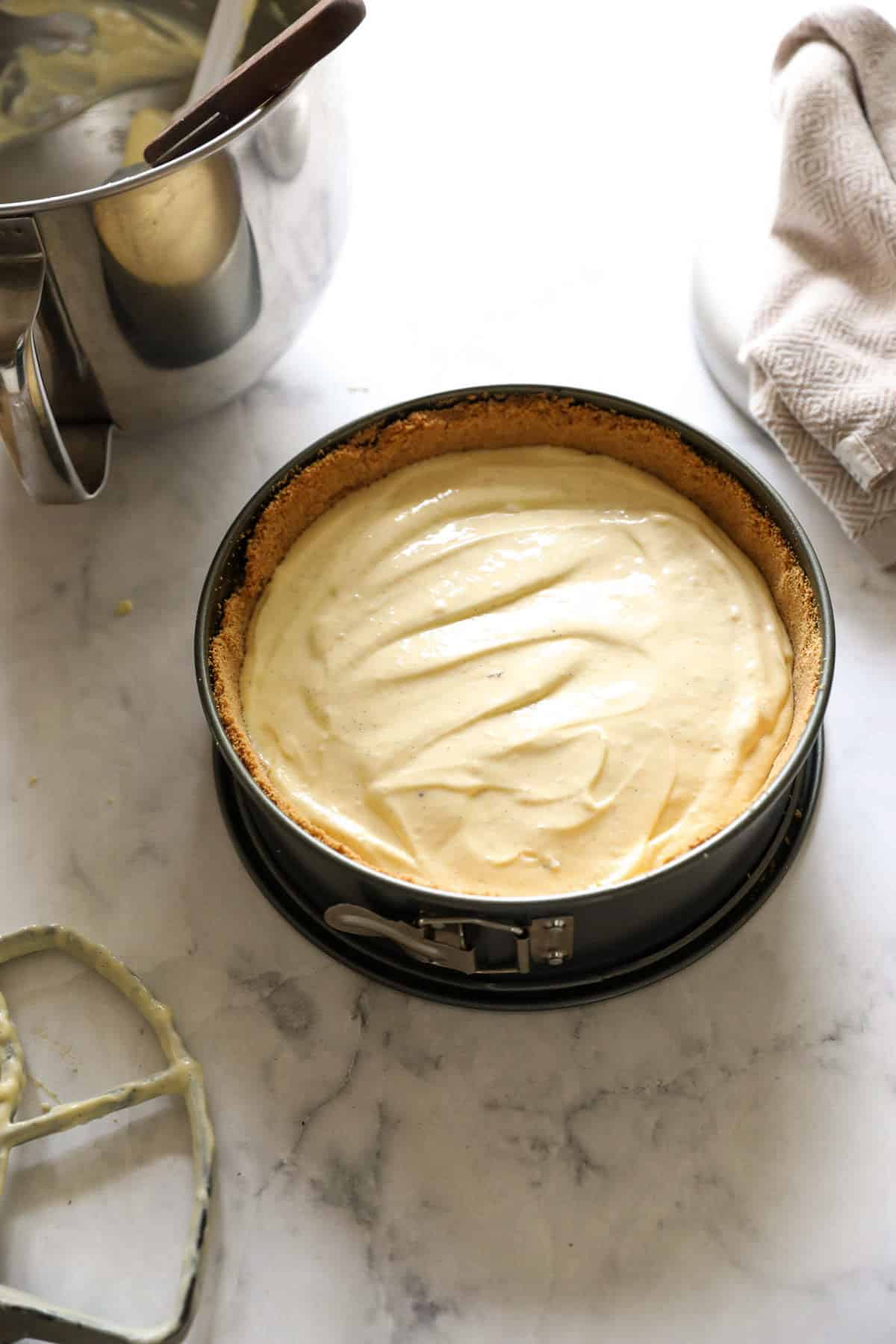 a cheesecake pan filled with cream cheese and sour cream filling