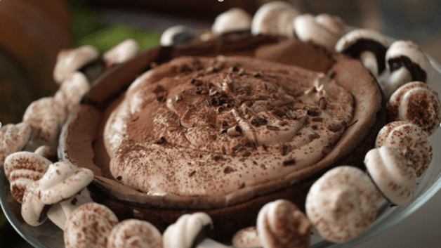 Fallen Chocolate Cake topped with chocolate whipped cream and meringue mushrooms