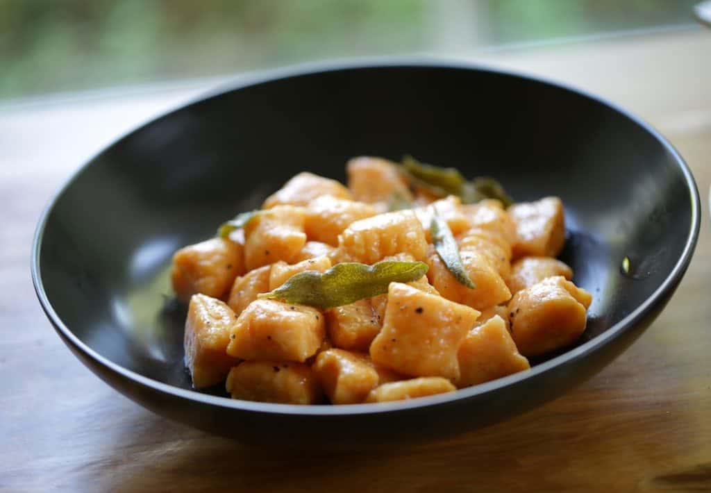 Sweet Potato Gnocchi with Brown Butter and Sage Recipe in a black bowl garnished with crispy sage leaves