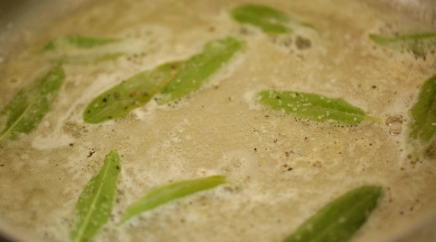 Sage and butter in pan seasoned with salt and pepper