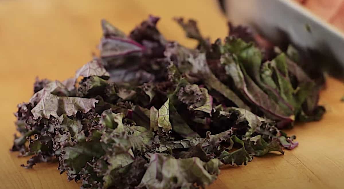 Red kale being chopped on a cutting board