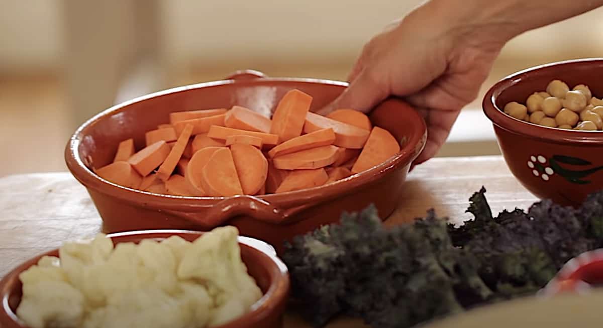 a person picking up a dish of sweet potatoes