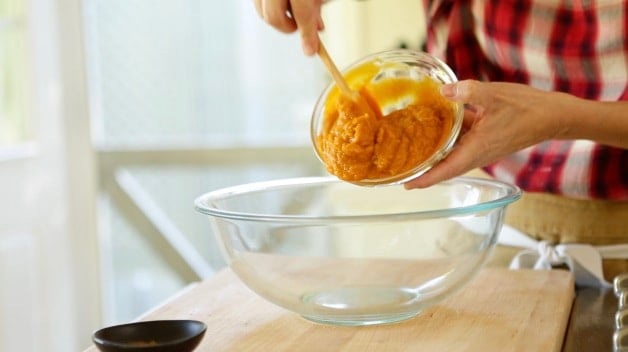 Pumpkin puree going into a glass bowl 