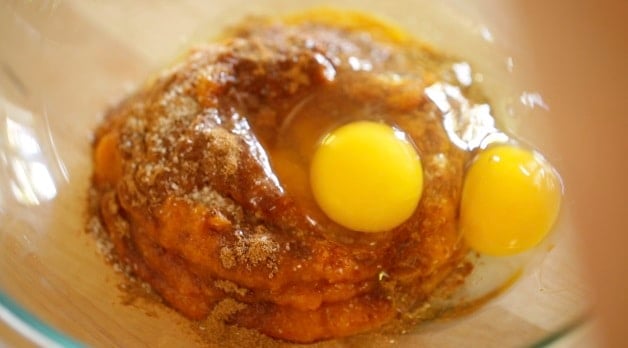 Pumpkin pie mixture in mixing bowl with eggs