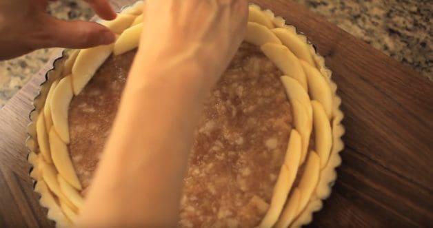 Adding apple slices to tart in an escargot pattern