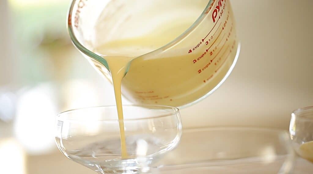 pouring creme anglaise into a bowl from a Pyrex Pitcher