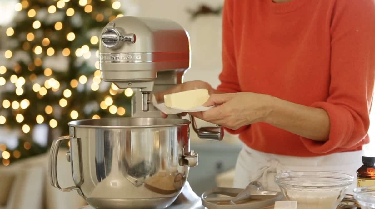 a person adding butter to a mixer