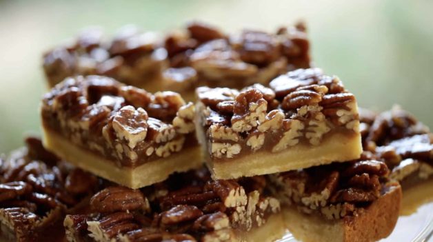 Pecan bars piled on a cake stand