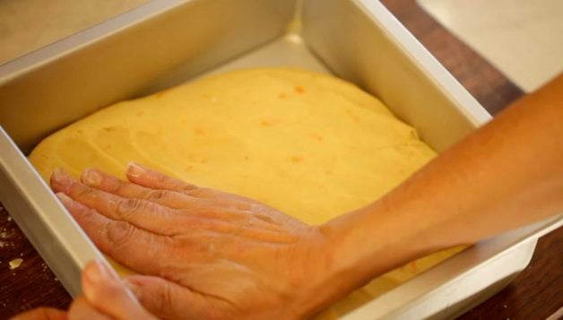 Pressing shortbread crust dough into a brownie pan 