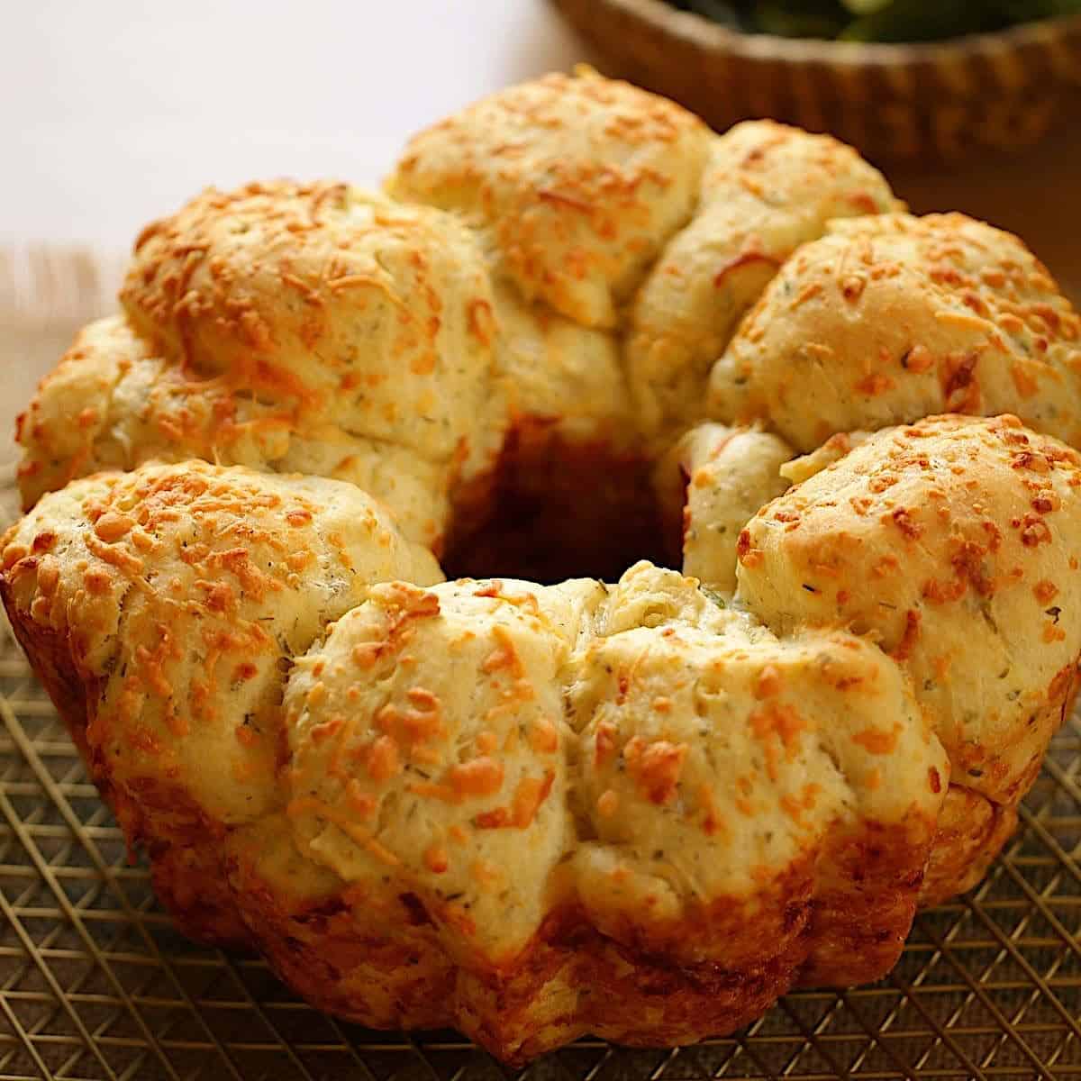 Savory Monkey Bread with Cheese on Top on a cooling rack