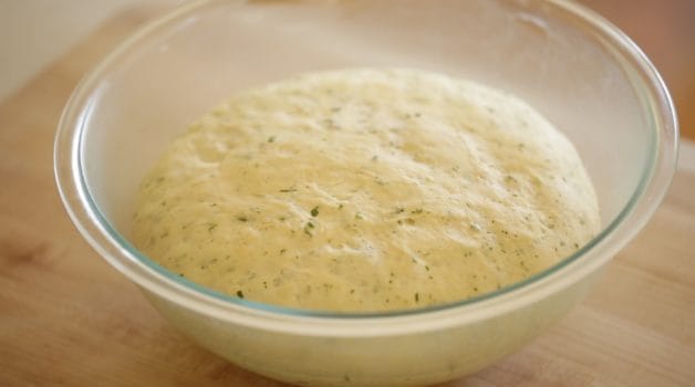 Risen dough with herbs in a bowl