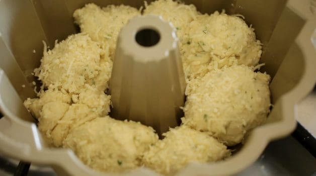 placing dough balls in bundt pan 