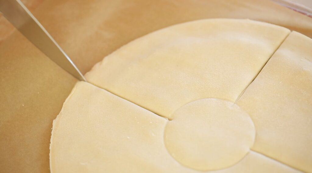 slicing a puff pastry round with a chef knife