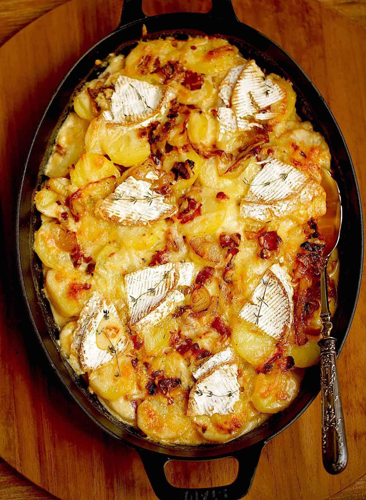 Tartiflette baked in a gratin dish with silver spoon