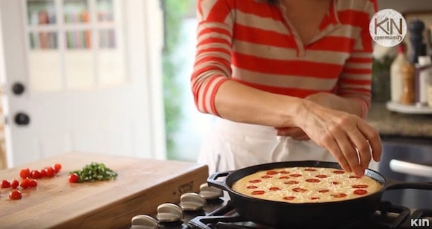 Adding Cherry Tomatoes to the top of a frittata in a skillet