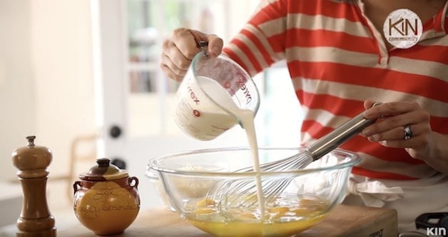 Heavy cream in pitcher added to eggs in a glass bowl