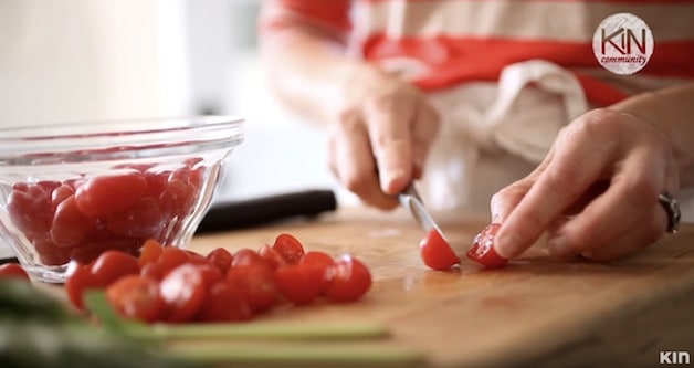 Cutting cherry tomatoes on a cutting board