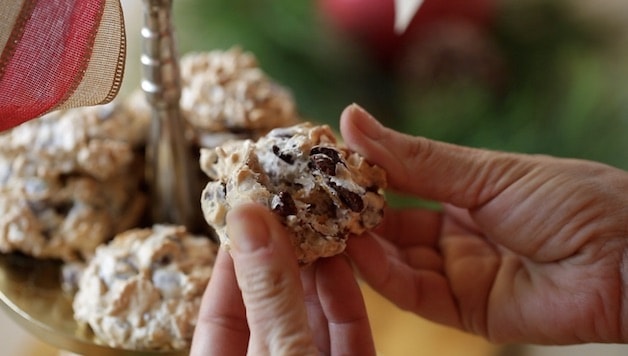 Christmas Cookie breaking apart to show the texture of chocolate chips, coconut and cornflakes