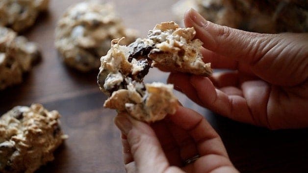 Cookie being pulled apart to show the texture of cocunut, chocolate chip and cornflakes