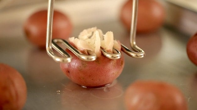 Smashing a red potato with a potato masher