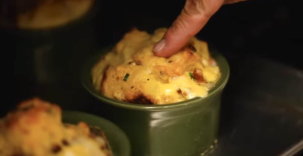 Fingertip checking doneness of egg bake