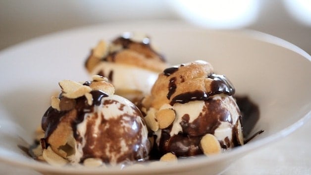 Profiteroles in a bowl topped with slice almonds