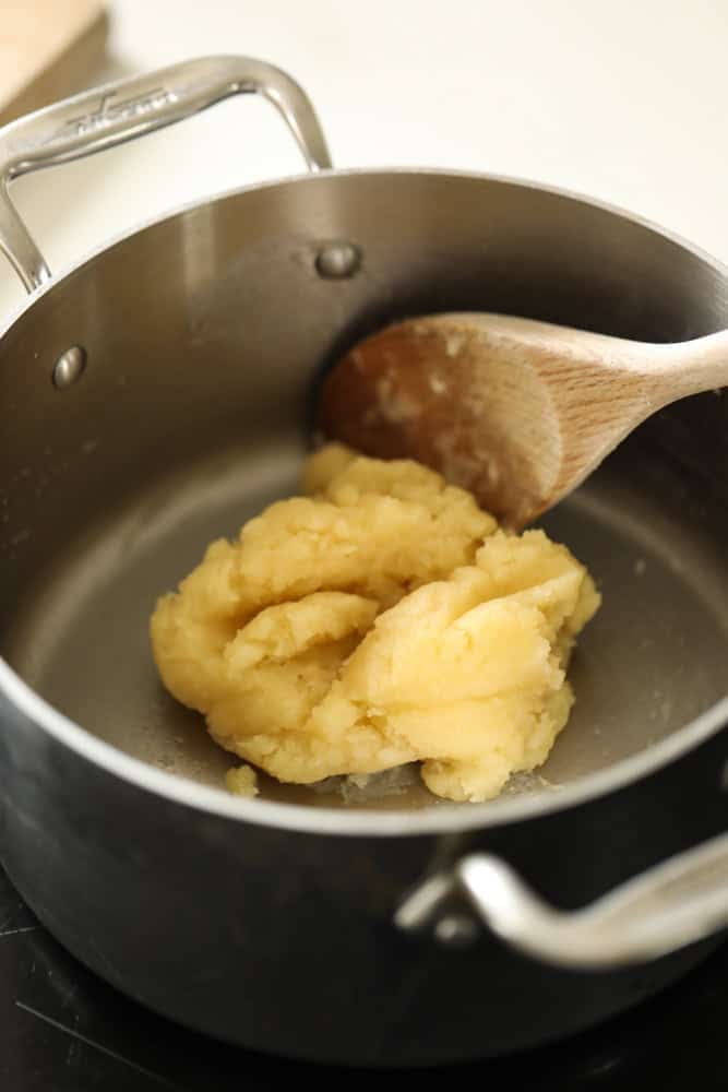 a dough ball in a pot that has come away from the sides.