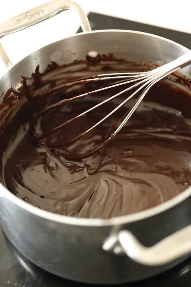 chocolate sauce in a pot with a whisk.