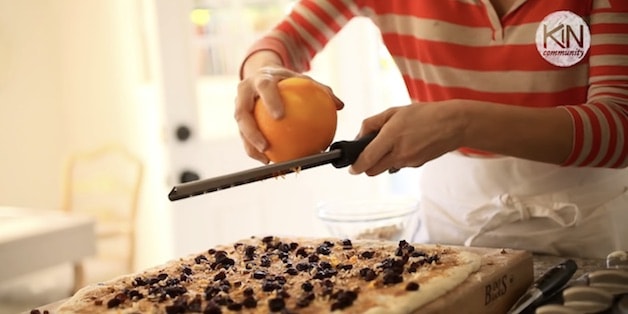 Grating orange zest on top of filling for sticky bun recipe. 