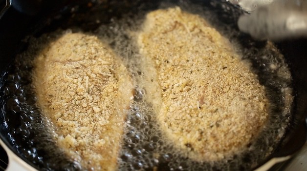 Breaded chicken cutlets frying in oil