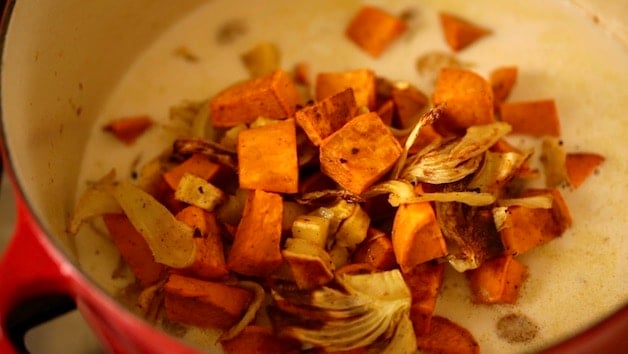 Roasted root vegetables in a pot with coconut milk