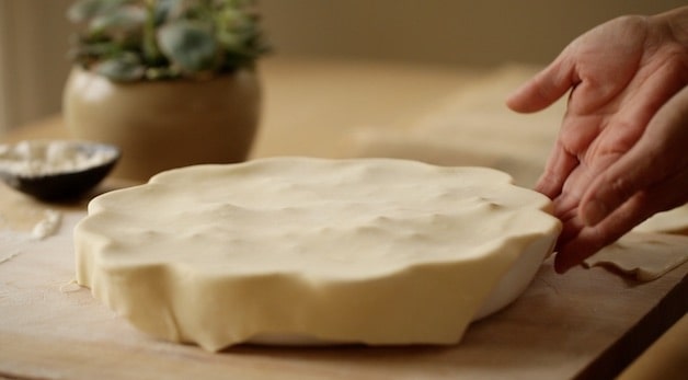 Pie Plate covered in pastry dough on cutting board