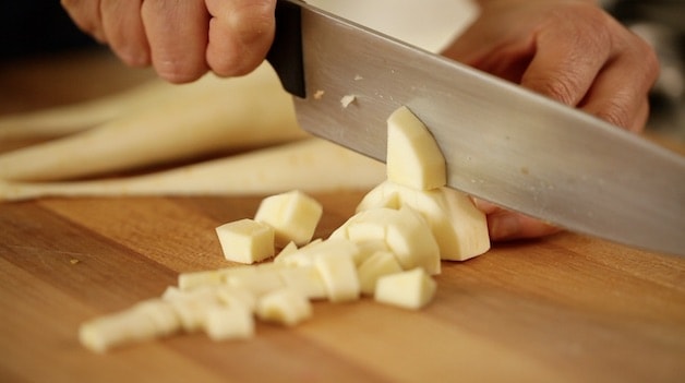Cutting parsnips with a large chef knife