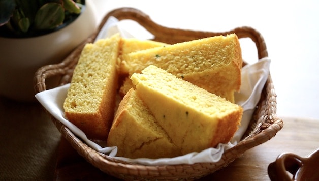 Cornbread wedges in a basket lined with a white napkin