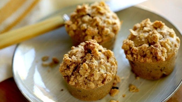 3 Apple Cinnamon Muffins with Oatmeal Crumb Topping on a wire cake stand