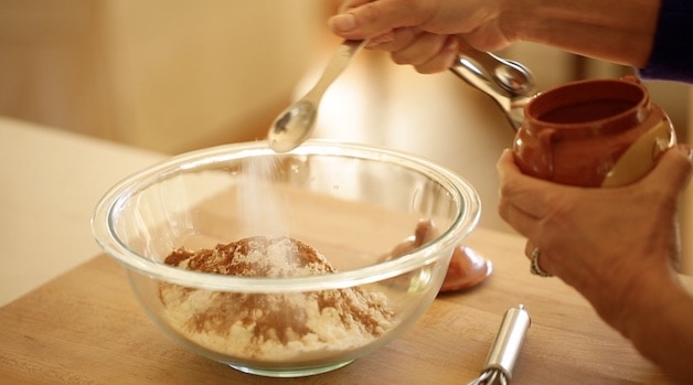 Adding Salt to dry ingredients and cinnamon in a glass bowl