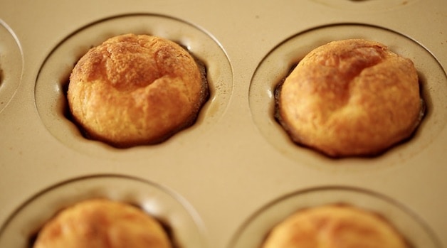 The golden brown tops of fresh caneles in a baking mold