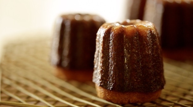 Two Caneles cooling on a cooling rack