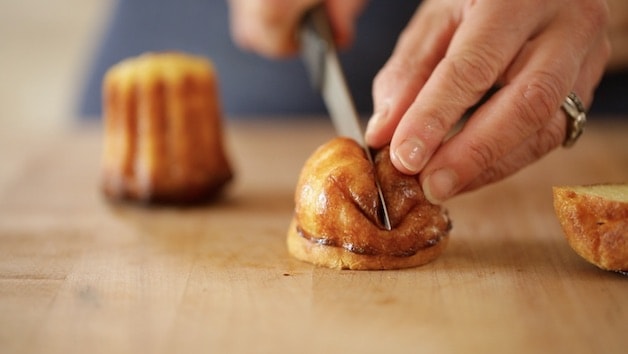 Cutting into a canele that was baked in a silicone mold and seeing it hard to cut because it\'s so squishy not caramelized