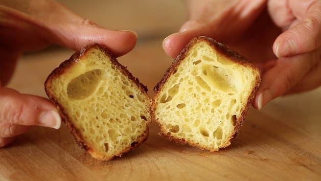 a canele cut in half showing the custardy interior texture