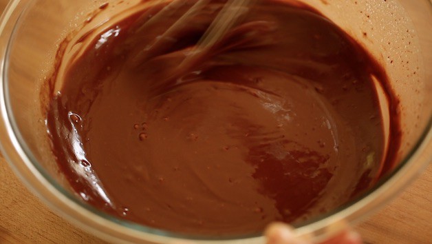 Melted Chocolate in a large glass bowl with whisk
