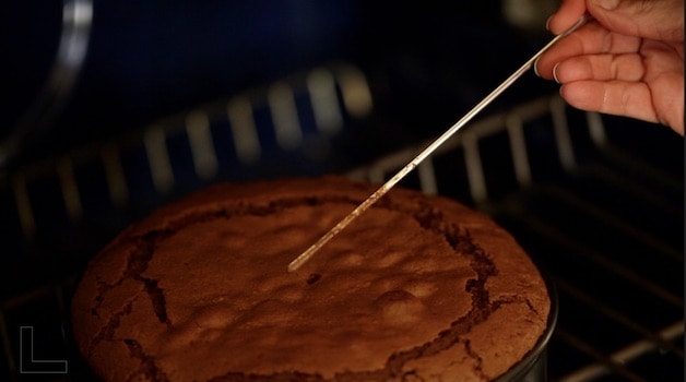 Inserting skewer into a flourless chocolate cake to check for doneness