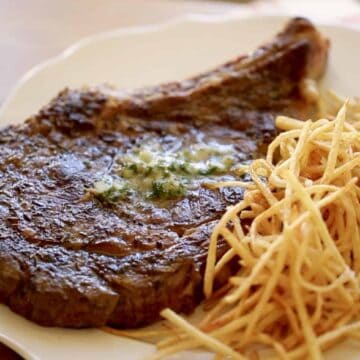 A rib-eye steak with Herb Butter on top and match stick French fries