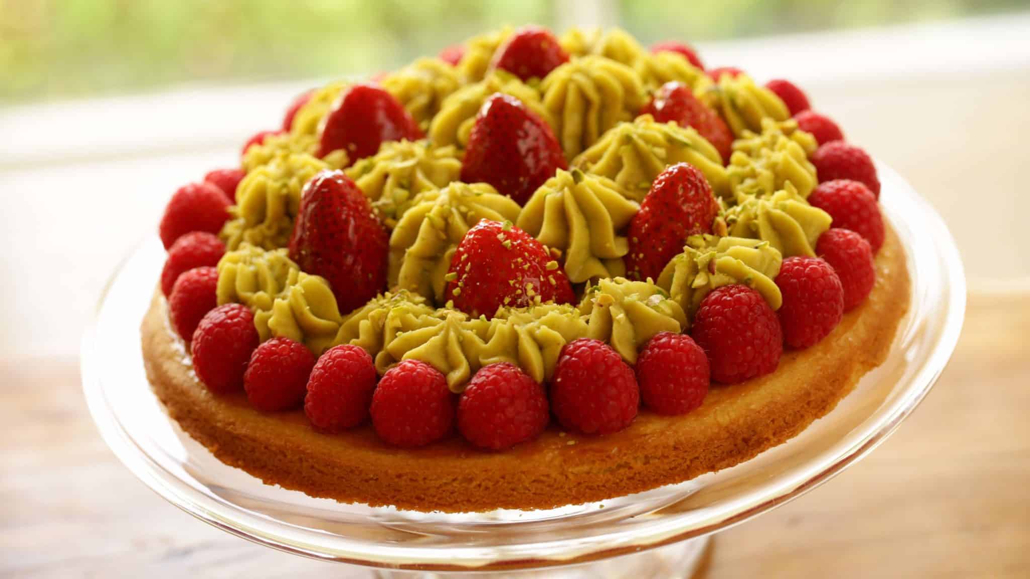 Strawberry Pistachio tart on a glass cake stand