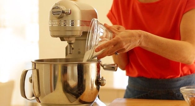 pouring sugar into a standing mixer