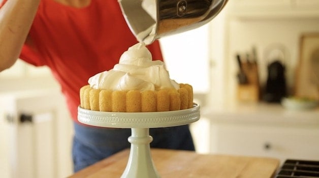 Pouring whipped cream into a sponge cake base