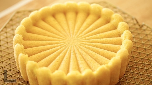 Sponge cake cooling on rack in the shape of a charlotte mold