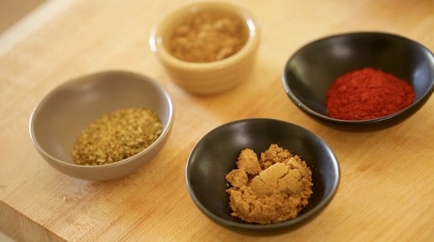 a selection of ground spices in small bowls for a carne asada marinade