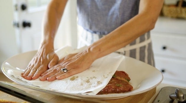 patting a marinated flank steak dry before grilling